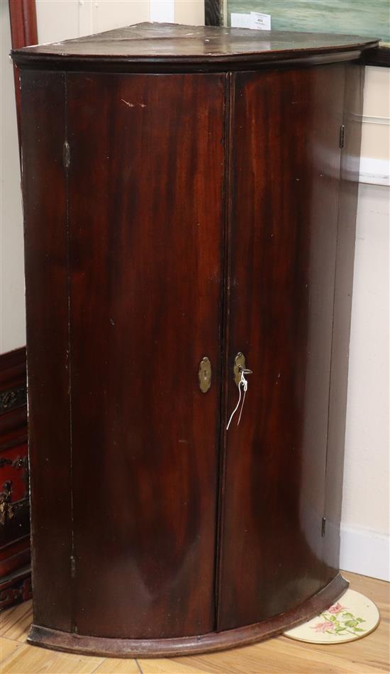 A George III mahogany bow front hanging corner cupboard W.65cm